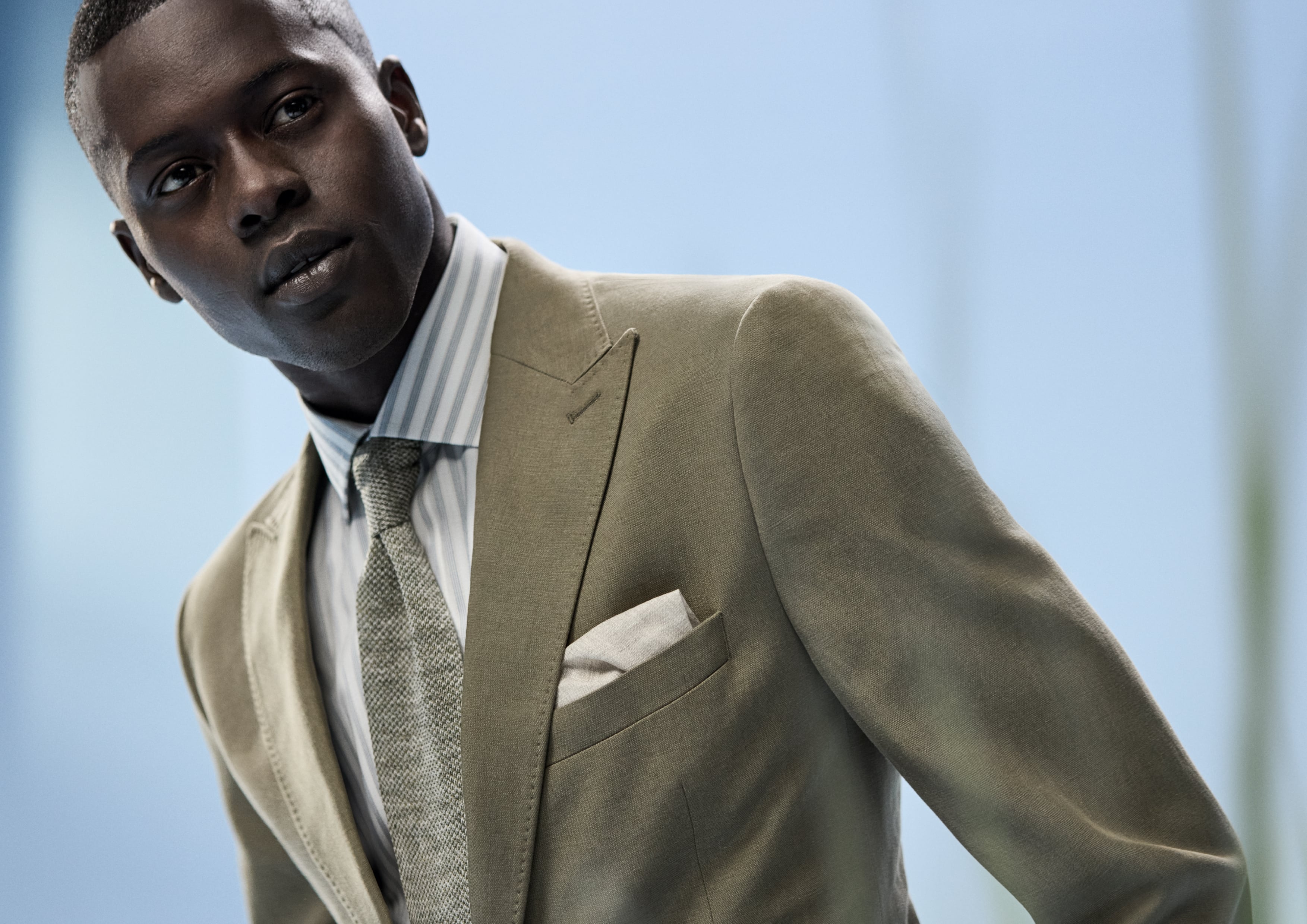 Model wears striped OLYMP shirt with a suit.