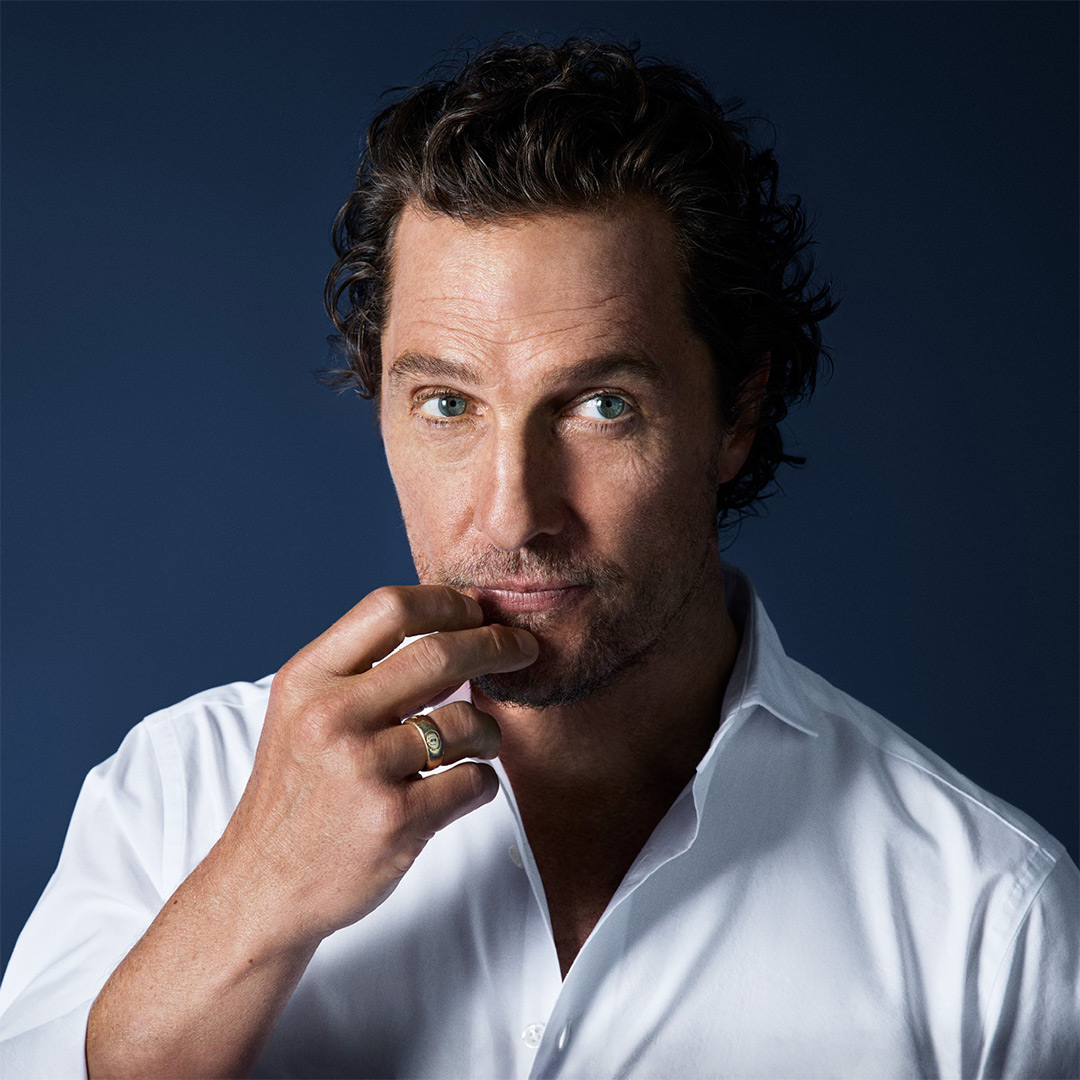 Matthew McConaughey in weißem OLYMP Hemd vor dunklem Hintergrund.